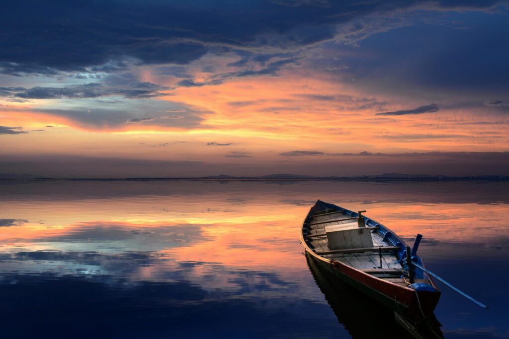 small sailboat on a calm sea at sunset
